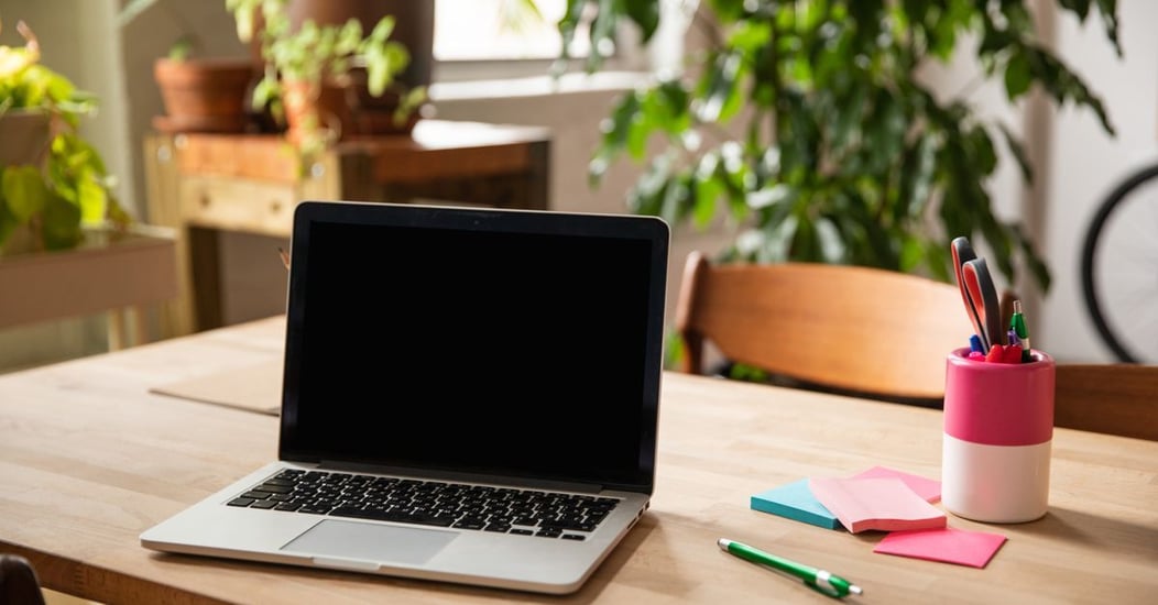 A modern workspace with a laptop and green plants, representing SEO evolving and being renewed rather than dying